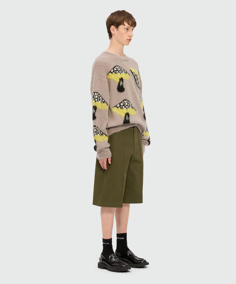Olive green Bermuda shorts in cotton drill with pleats and MSGM logo worn with a patterned sweater.