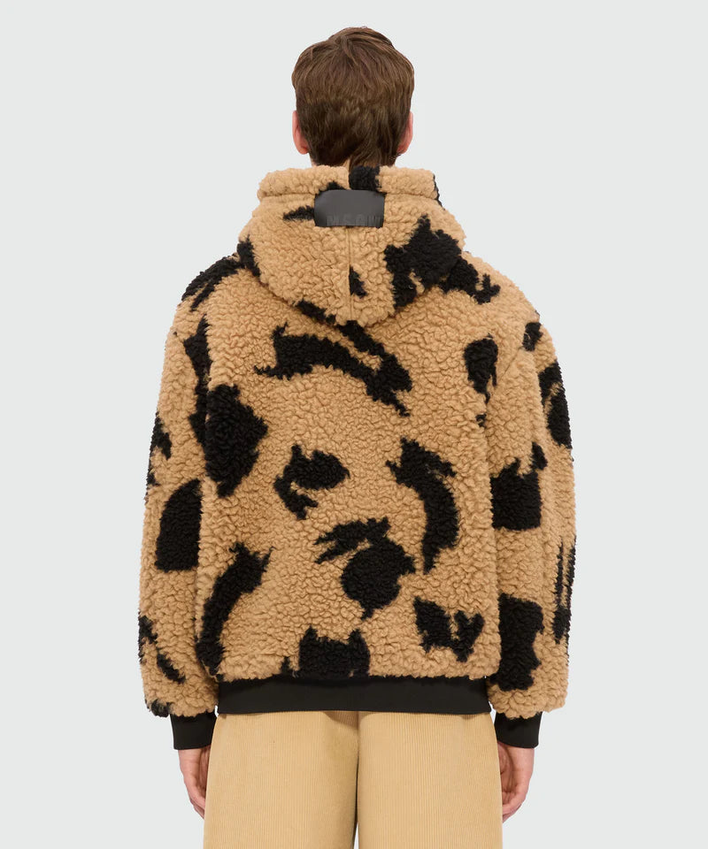 Beige teddy jacket with black motifs, featuring a drawstring hood and kangaroo pockets, shown from the back.
