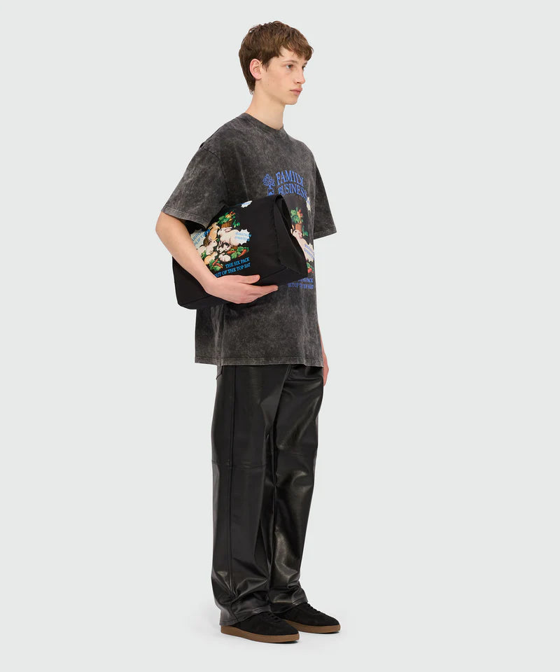 Black marbled jersey T-shirt with 'Family Business' print, oversized fit, worn with black pants.