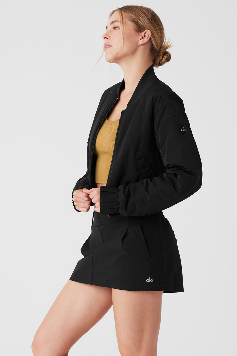 Model wearing a cropped break line bomber jacket with a ribbed collar and two front pockets.