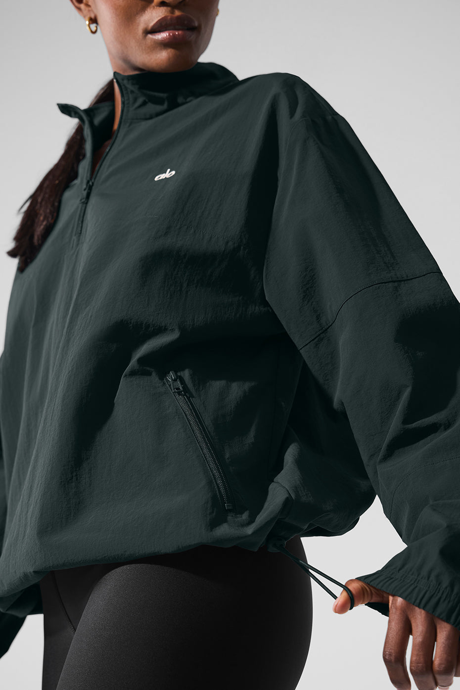 Light Weight Takeaway Track Pullover in dark color with quarter-zip neck and zippered pockets, model wearing relaxed fit.