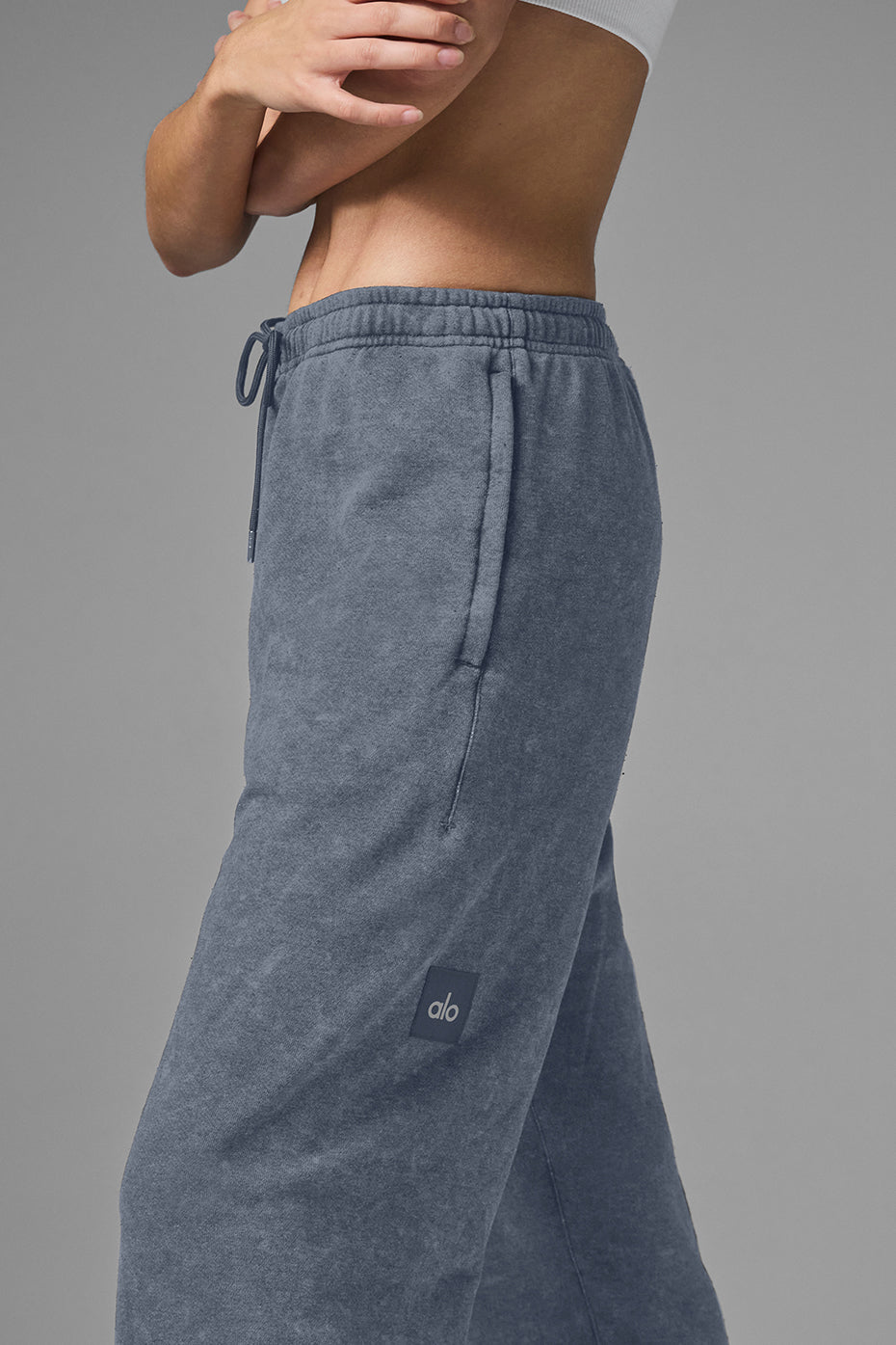 Model wearing Chill Vintage Wash Sweatpant in faded blue with stretchy drawstring waist and side pockets.