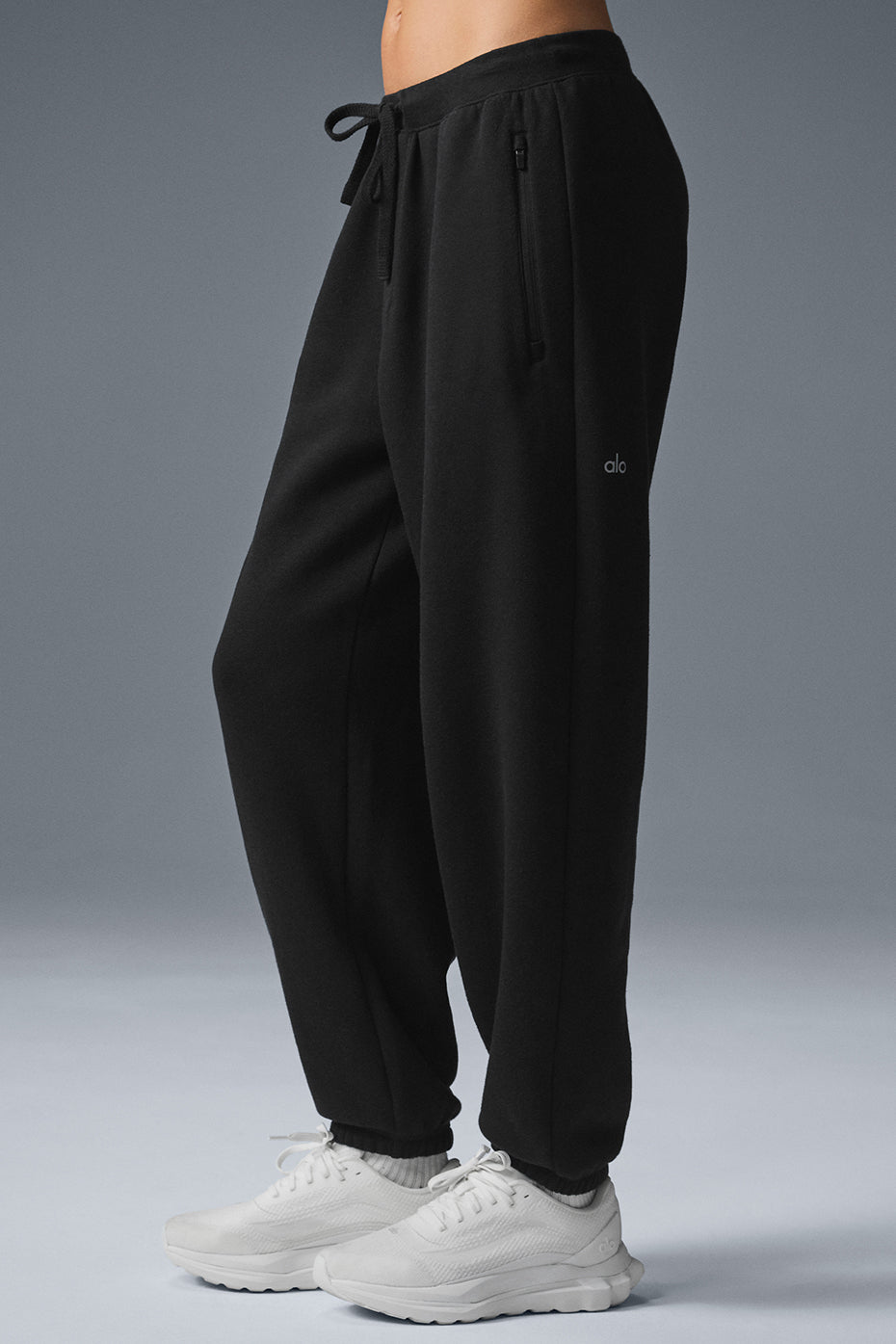Triumph Restore Sweatpant in black with zippered pockets and drawcord waist, providing a cozy oversized fit.