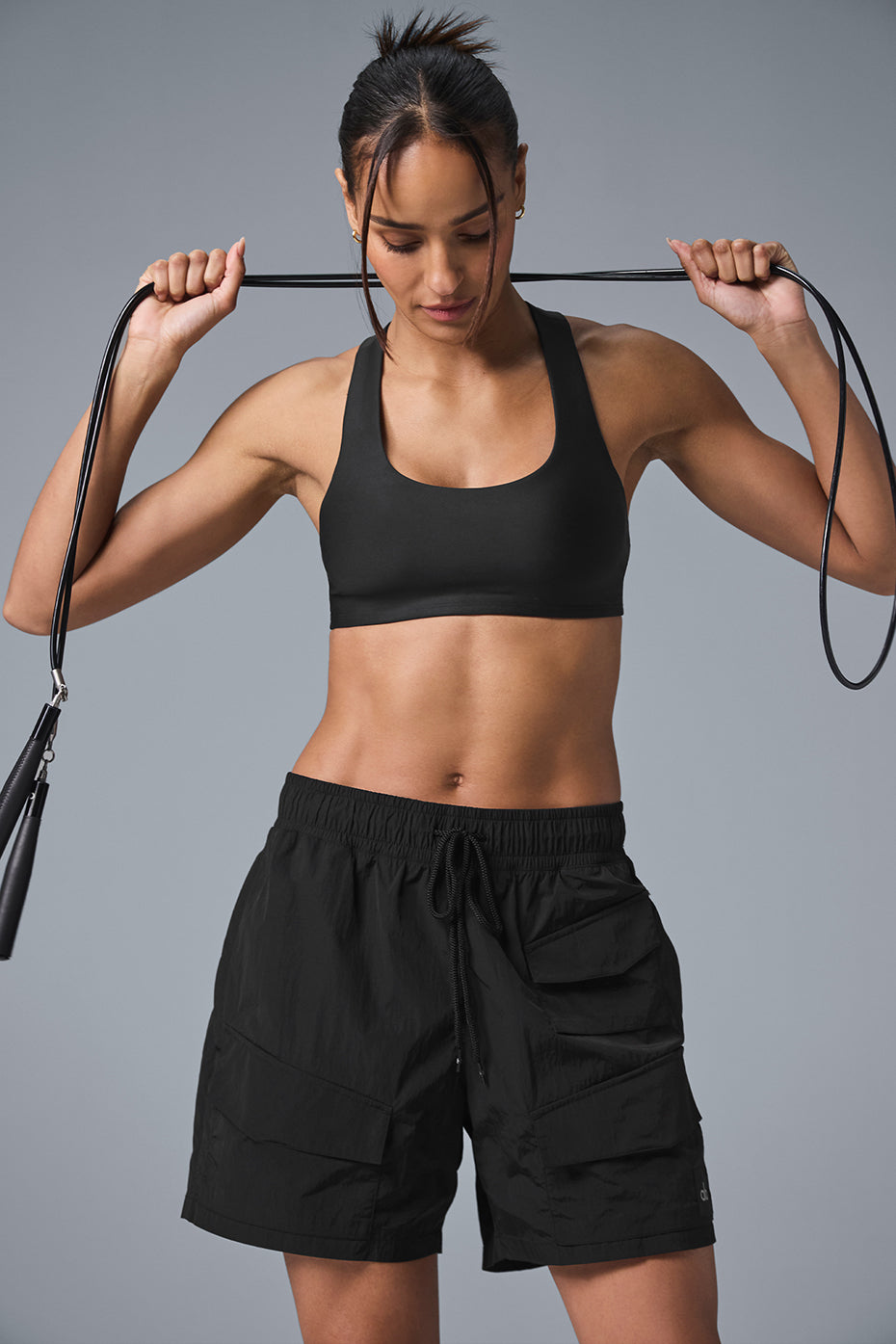Model wearing 7" crinkle nylon excursion cargo shorts and a black sports bra, showcasing a relaxed fit.