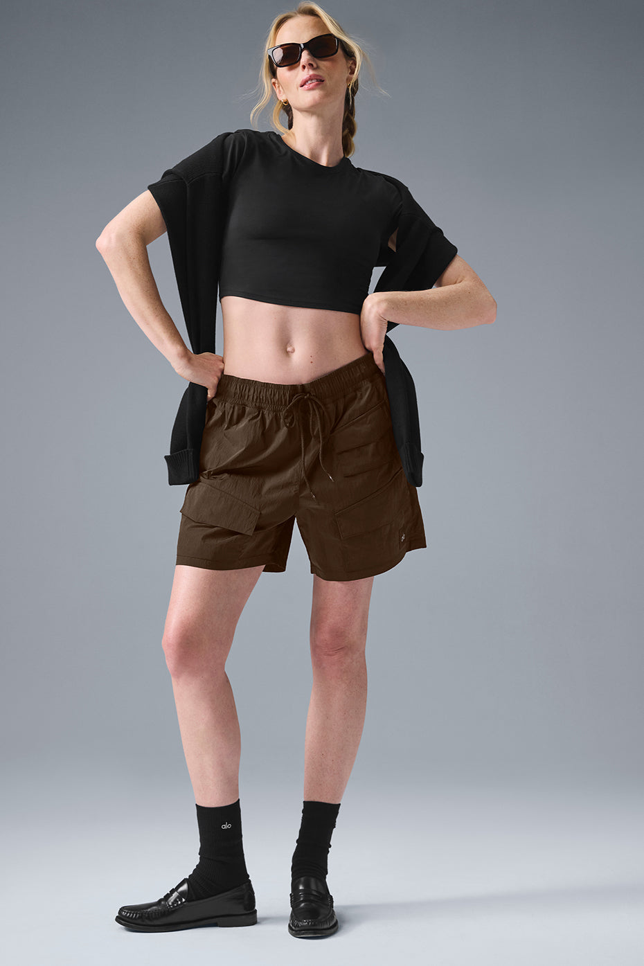 Model wearing 7" crinkle nylon excursion cargo shorts with drawstring waist and zippered pockets, styled casually.
