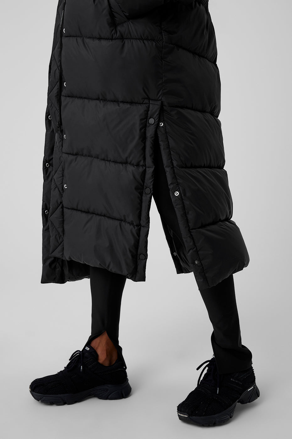 Black Gold Rush Puffer Trench featuring a buttoned side slit and oversized fit, perfect for winter weather.