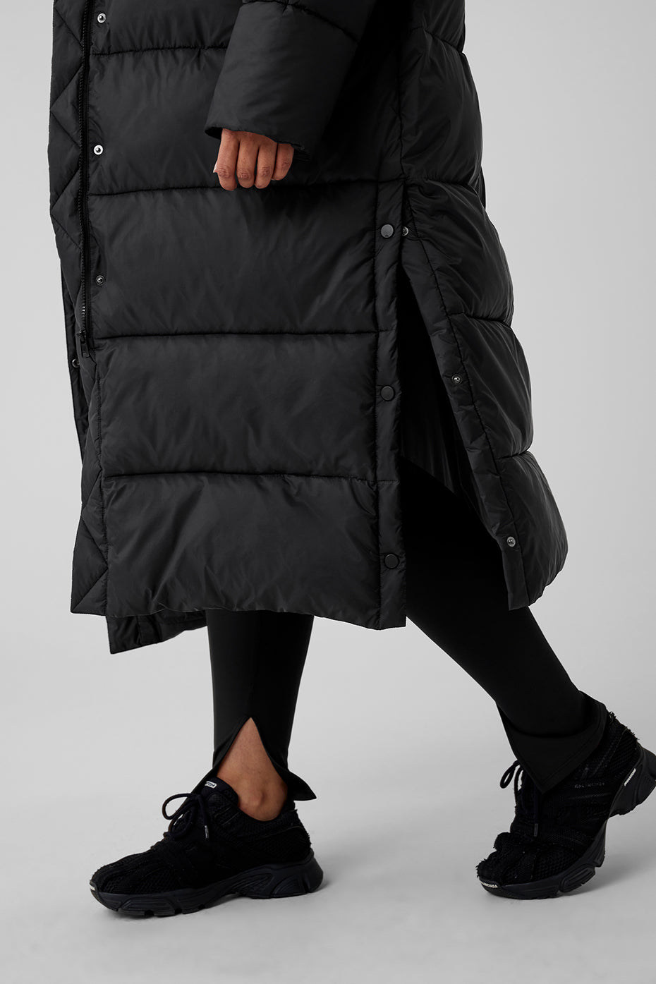 Woman wearing a black Gold Rush Puffer Trench coat with oversized fit, showing stylish winter outerwear.