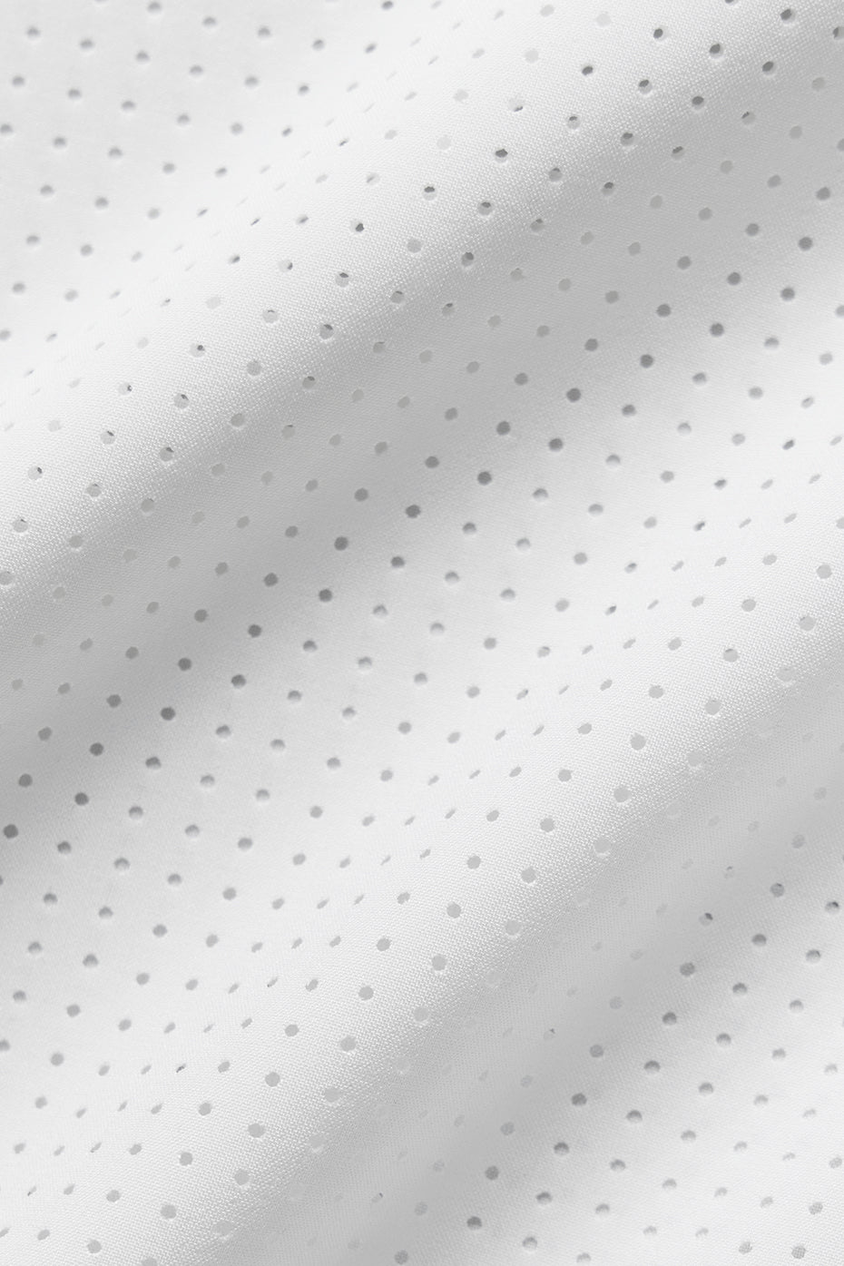 Close-up of lightweight white perforated fabric, showcasing the breathable texture for the Mesh Cropped Mirage Tee.