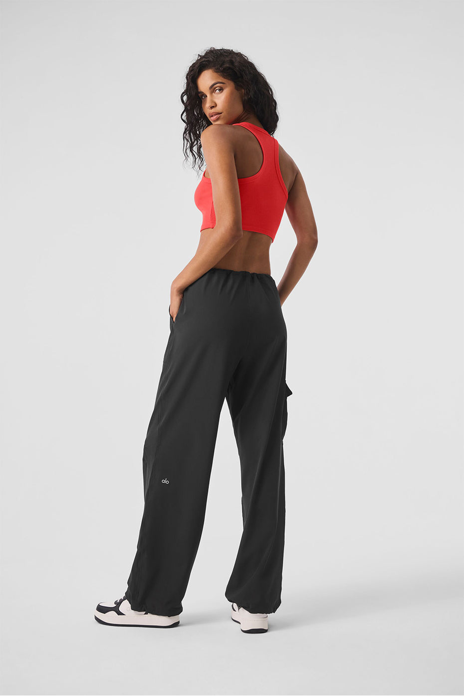 Woman wearing a red Aspire Tank and black pants, showcasing a casual and comfortable outfit for everyday wear.