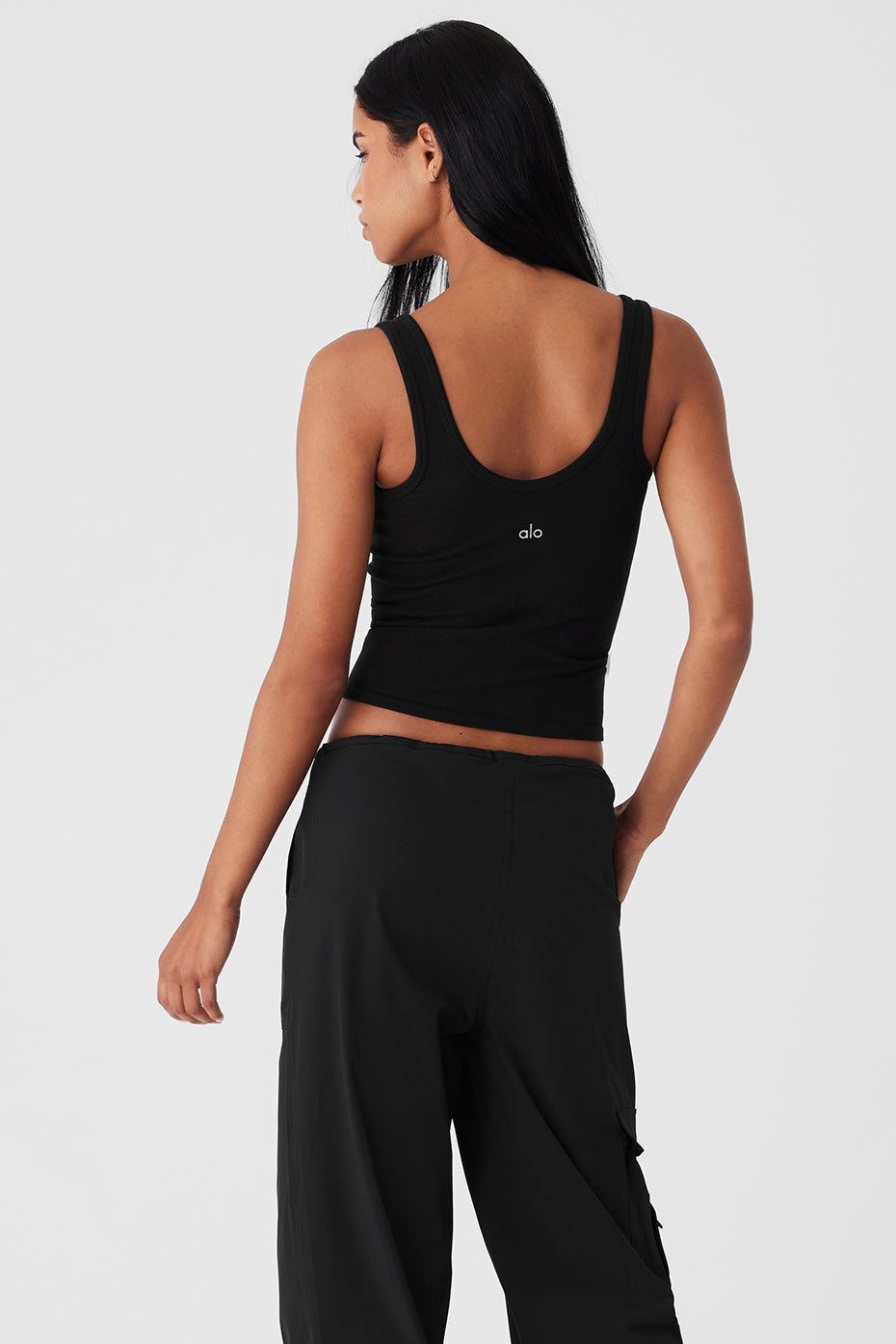 Back view of a woman wearing a Seamless Chosen Tank in black, highlighting the scoop neckline and fitted silhouette.