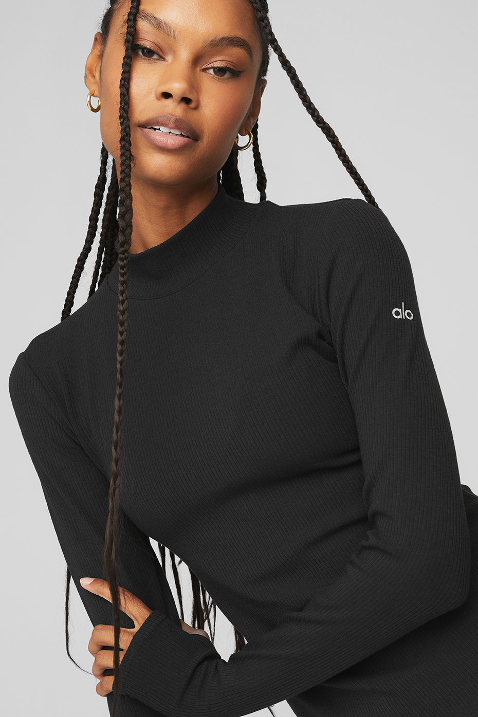 Model wearing Wellness Rib Mock Neck Long Sleeve top in black, showcasing sleek design and ribbed fabric.