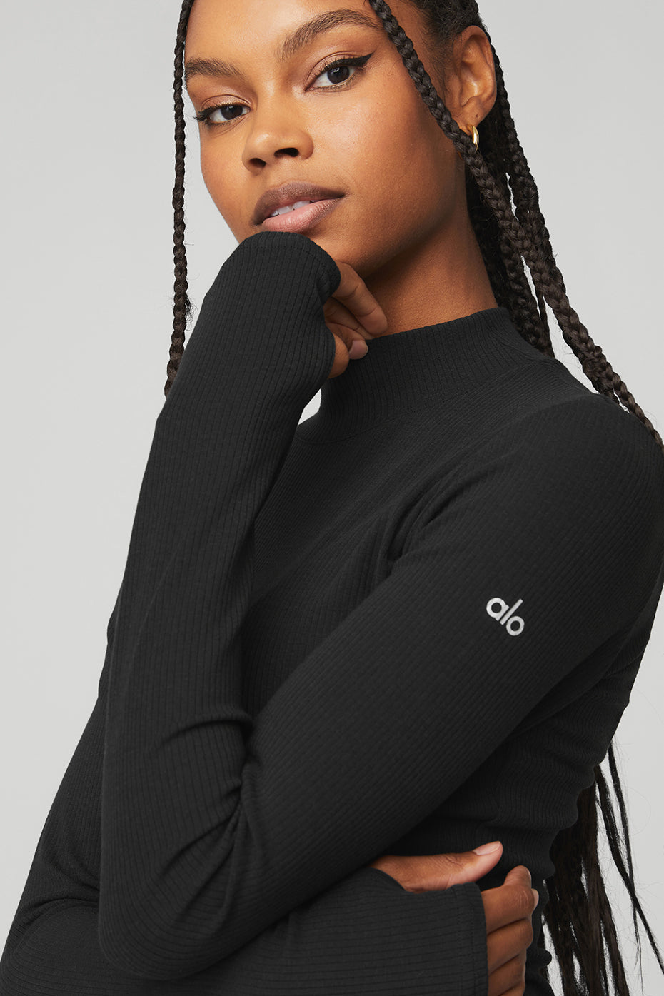 Model wearing black Wellness Rib Mock Neck Long Sleeve top, showcasing its sleek design and ribbed fabric.