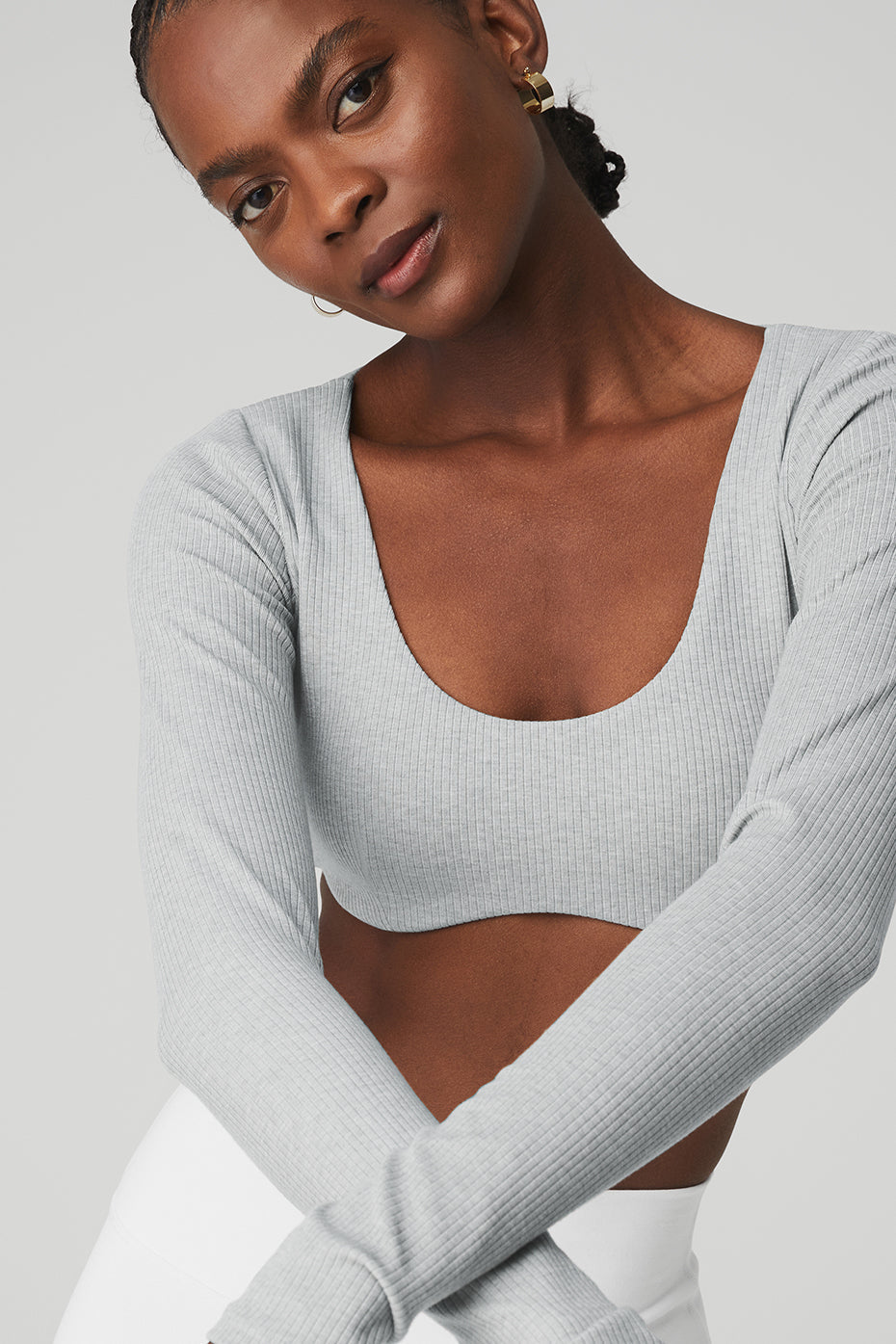 Model wearing a light gray ribbed defined long sleeve bra with a scoop neck, showcasing comfort and style.