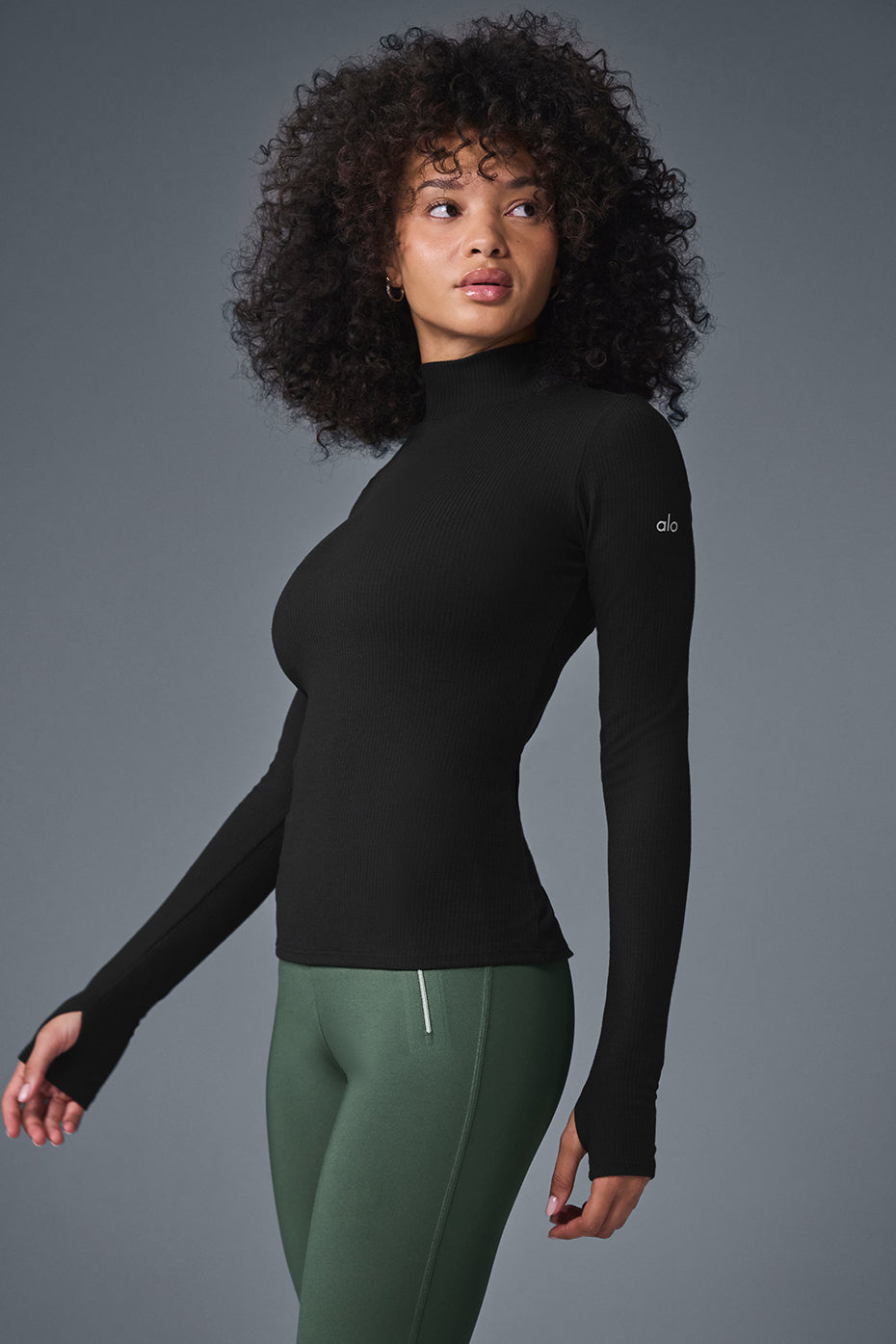 Wellness Rib Mock Neck Long Sleeve top for women in black, featuring a sleek design, ribbed fabric, and thumbhole cuffs.