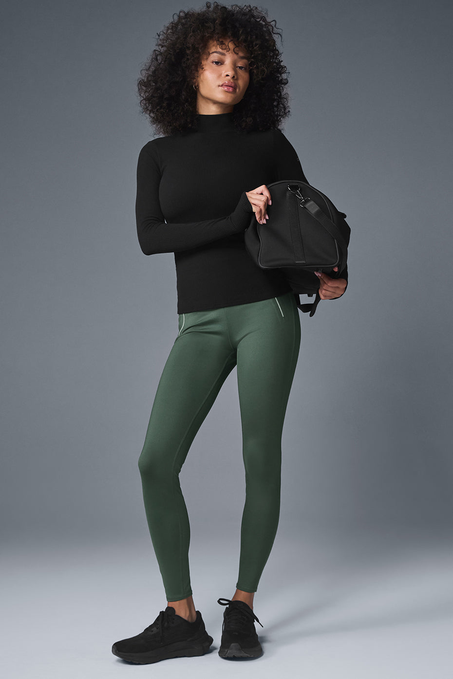 Model wearing Wellness Rib Mock Neck Long Sleeve top with high-waist leggings, showcasing a sleek, stylish athleisure look.
