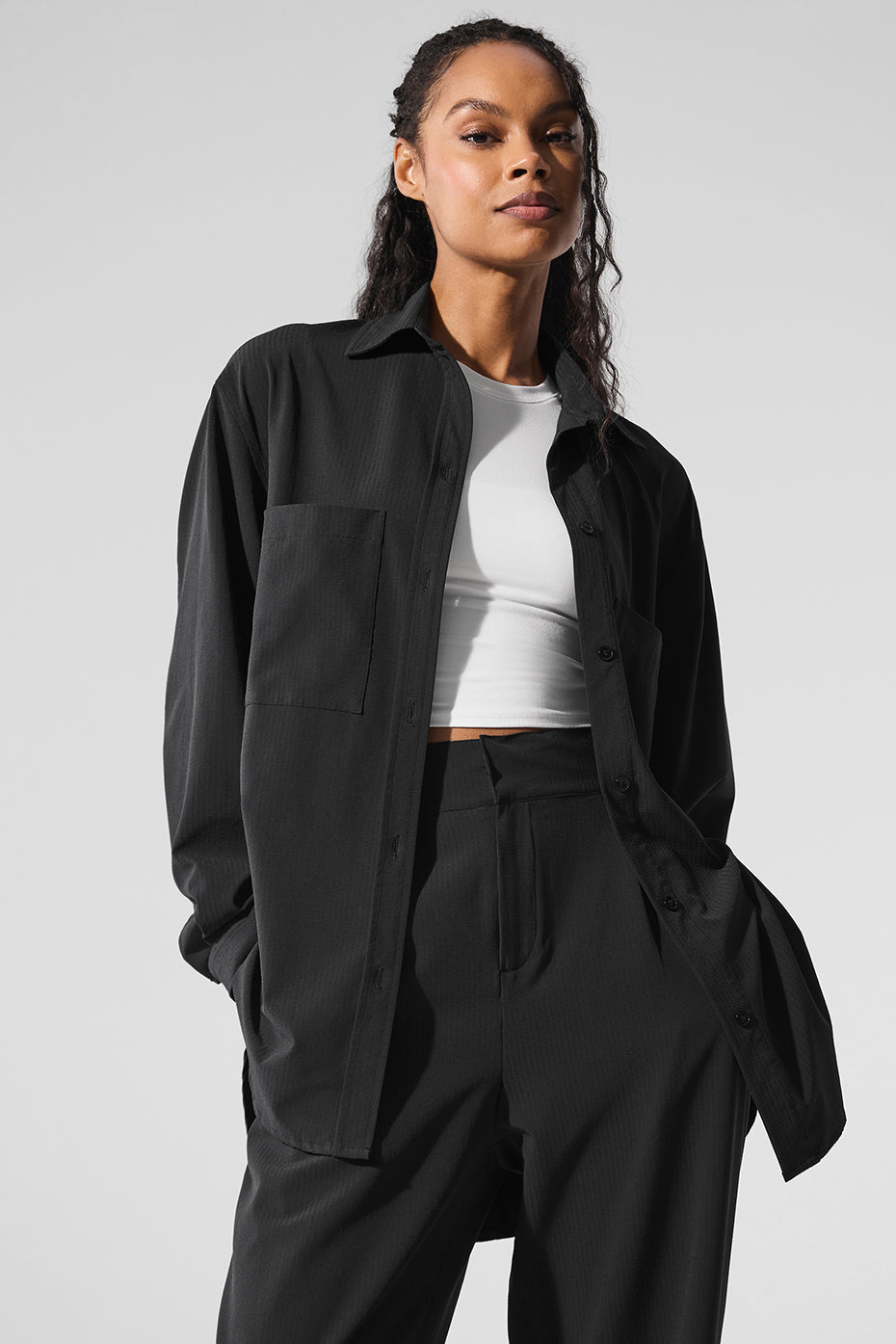 Model wearing the Dreamscape Button Down Long Sleeve shirt in black with front pockets and oversized fit.