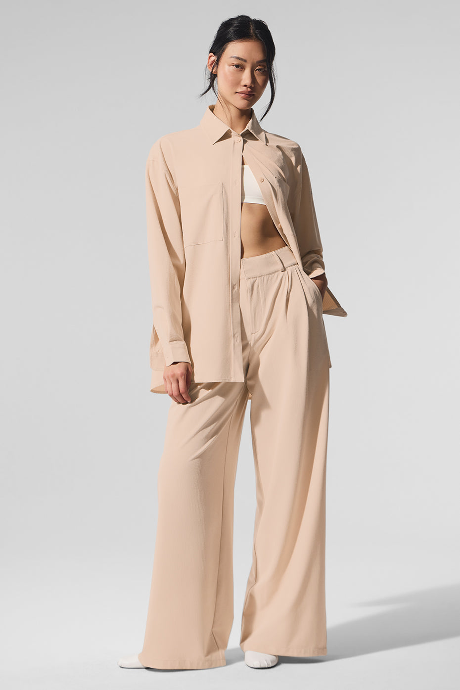 Dreamscape Button Down Long Sleeve in beige worn with matching high-waist trousers, featuring oversized design and front pockets.