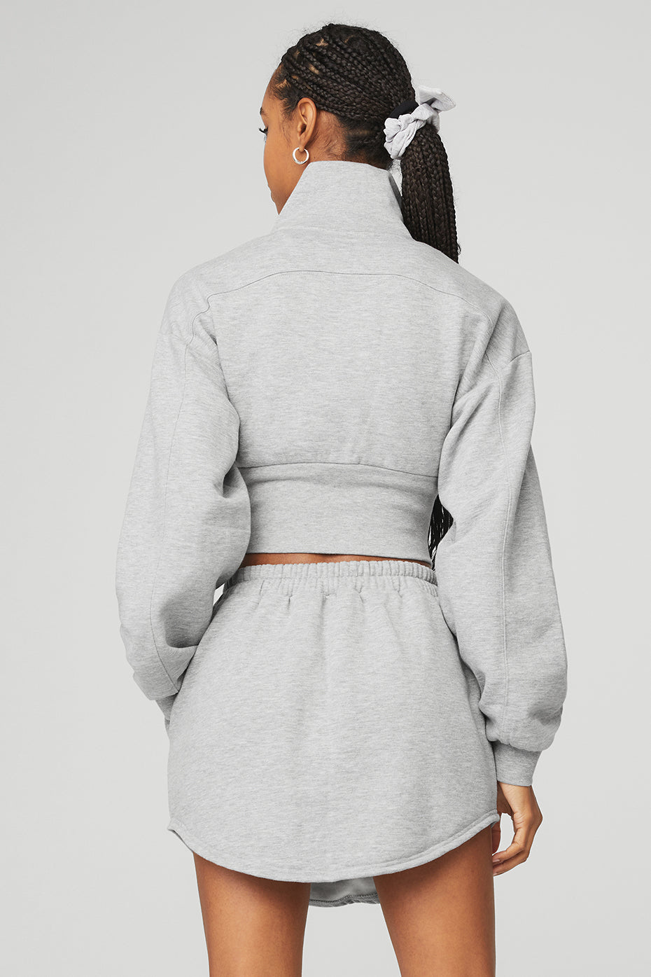 Back view of a woman in a grey Vixen Fleece 1/4 Zip, featuring a cropped design and high neck, styled with a relaxed fit.