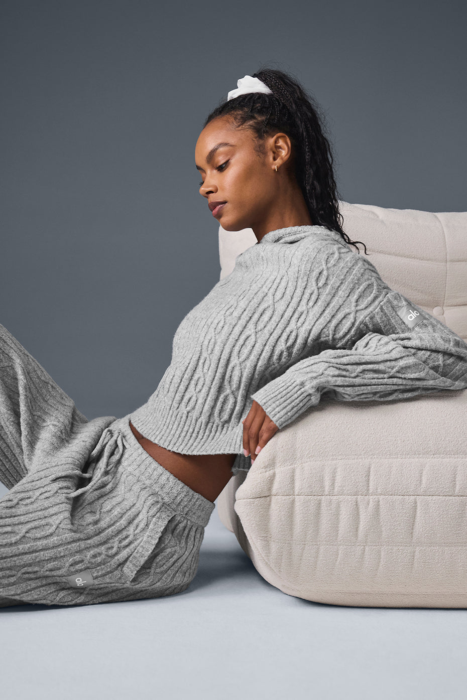 Model wearing a cozy cable knit winter bliss hoodie in gray, styled with matching pants for a relaxed autumn look.