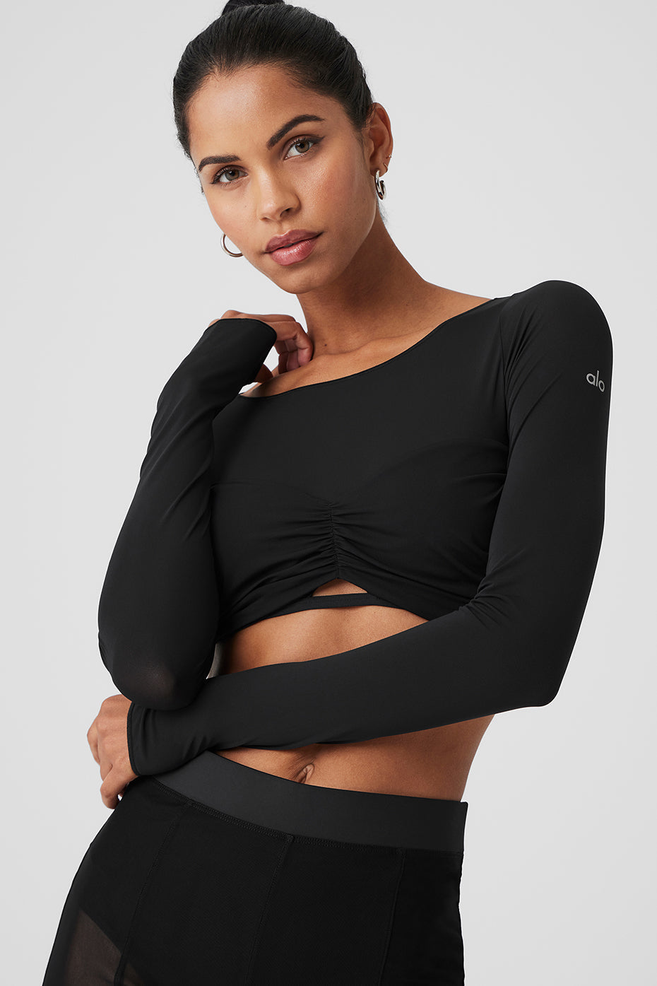 Model wearing Mesh Sheer Illusion Cropped Long Sleeve top with boat neck and gathered front detail.
