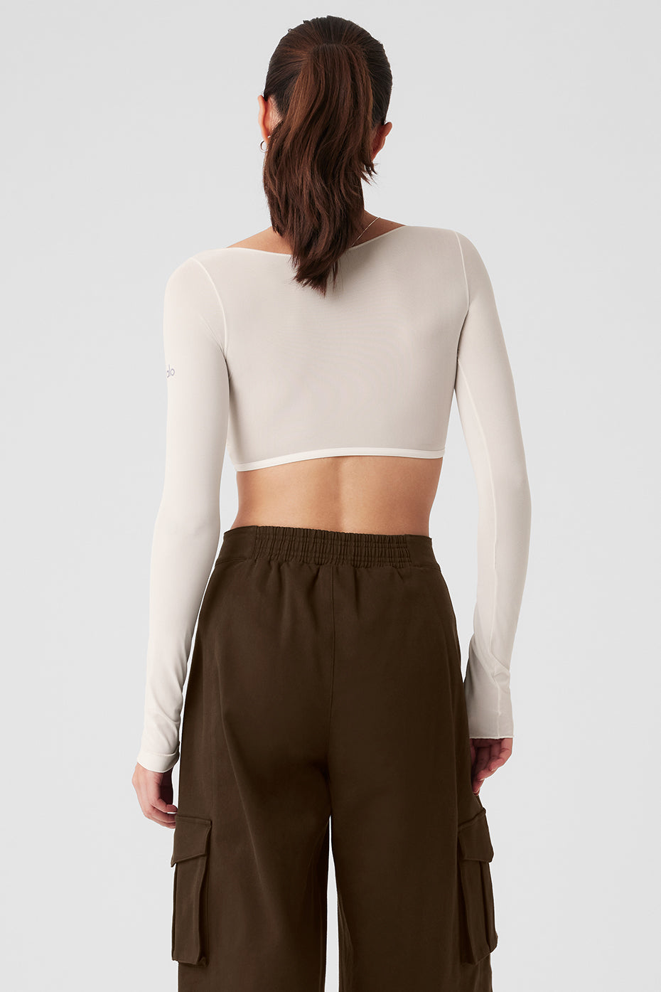 Back view of Mesh Sheer Illusion Cropped Long Sleeve top paired with high-waisted cargo pants.