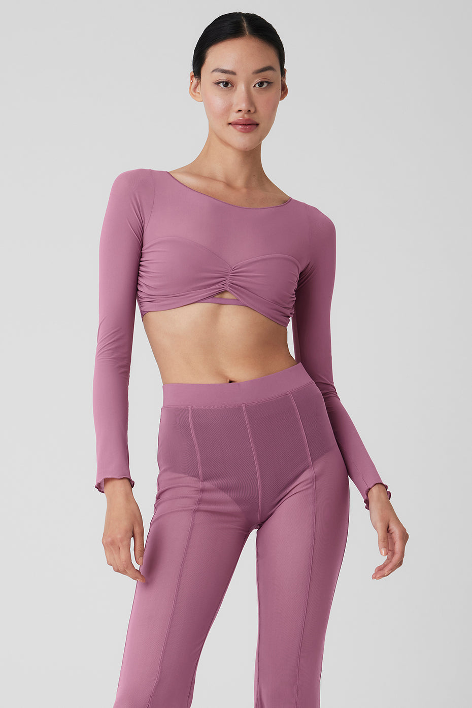 Model wearing Mesh Sheer Illusion Cropped Long Sleeve top with gathered front and rib-grazing cut, paired with matching high-rise pants.