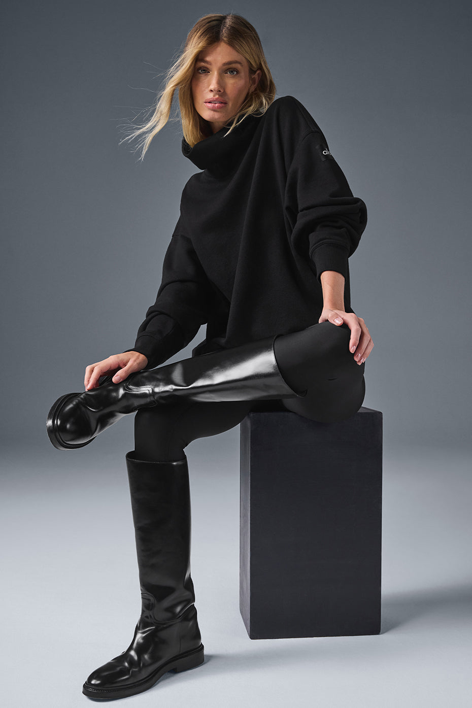 Hazy Mock Neck Pullover in black worn with sleek leggings and stylish boots, showcasing a cozy oversized fit.