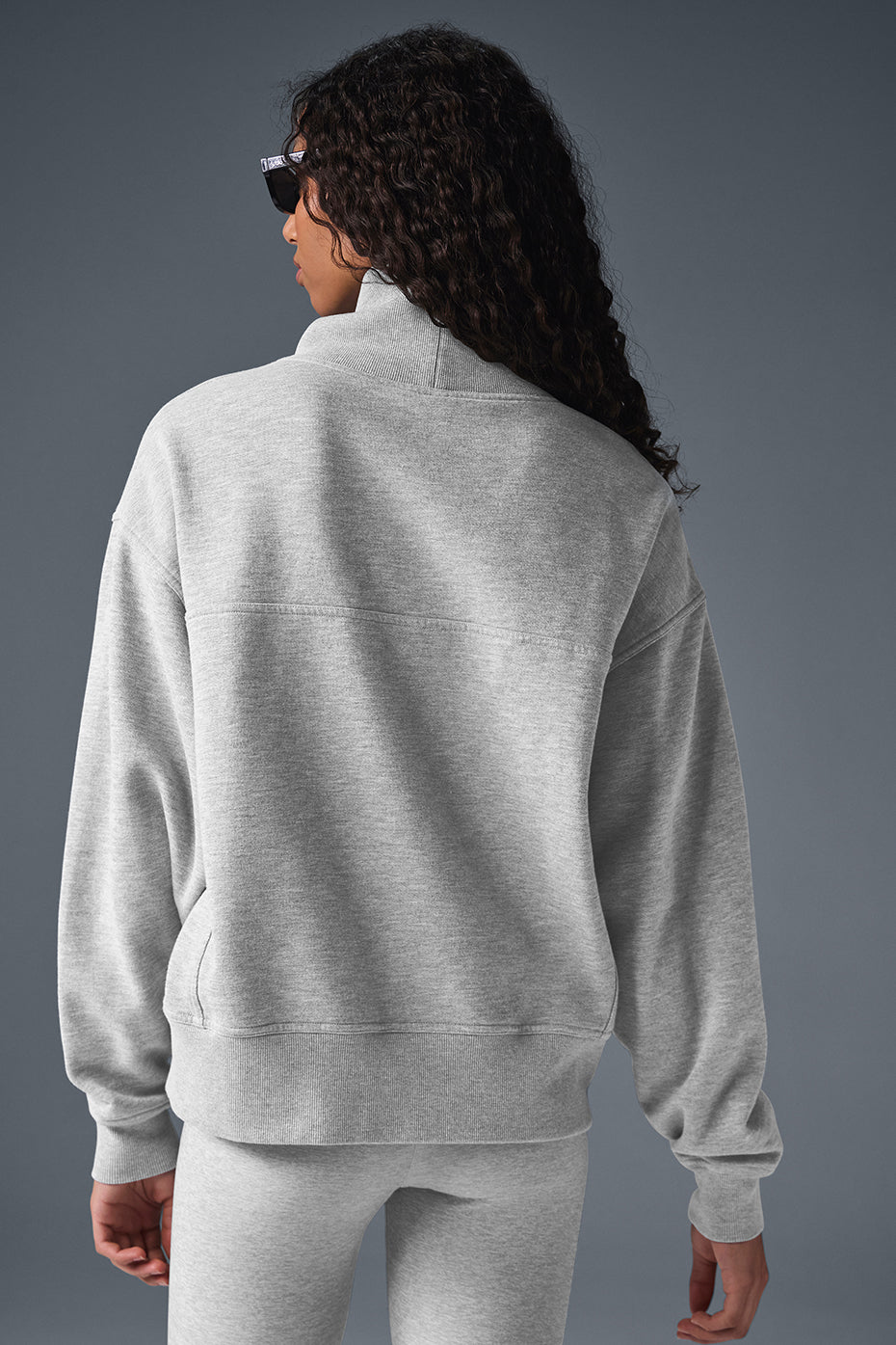 Back view of a model wearing a soft gray Hazy Mock Neck Pullover sweater in an oversized fit.