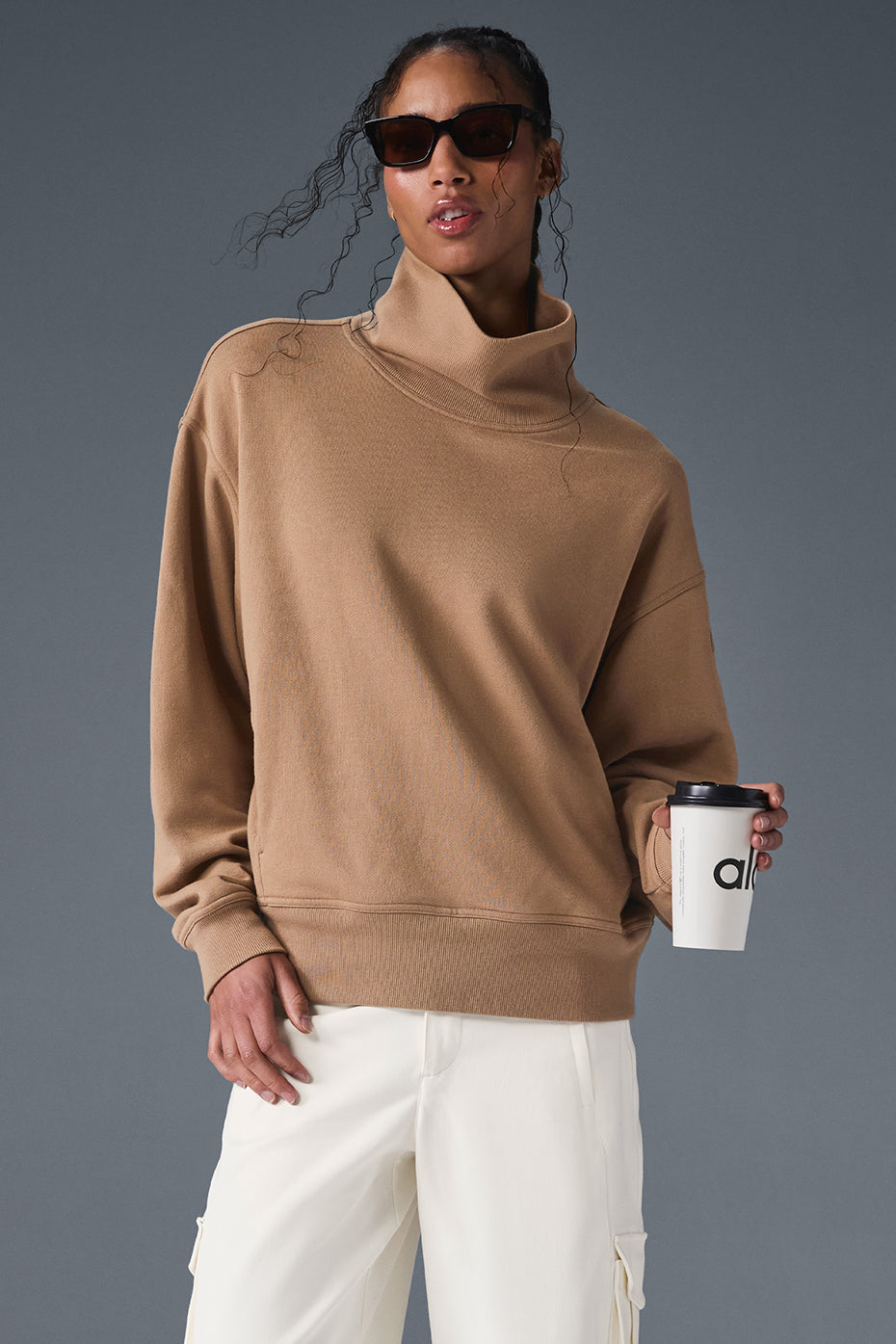 Hazy mock neck pullover in soft brown, styled with cargo pants for a cozy, oversized look.