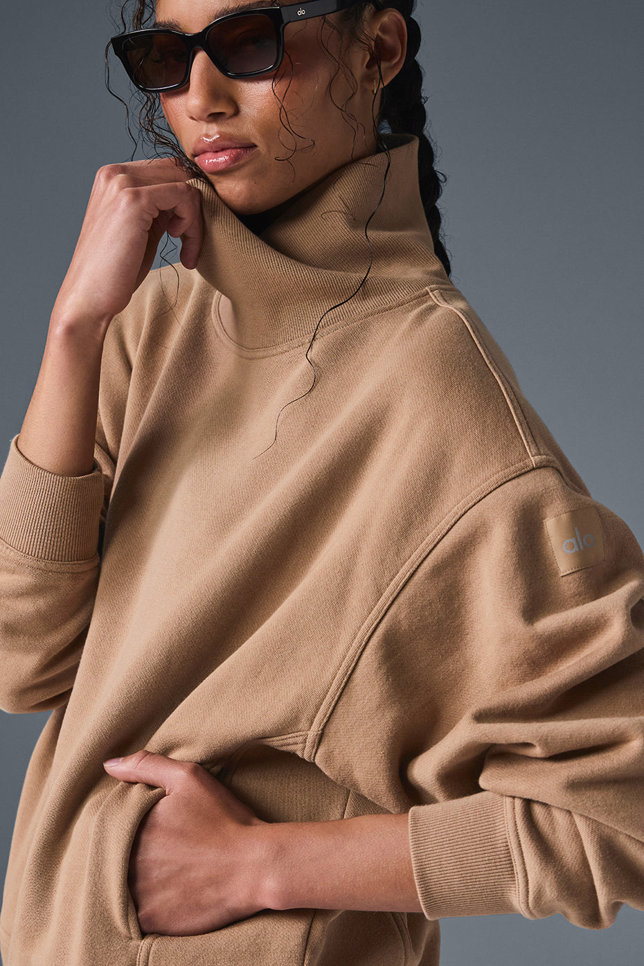 Woman wearing soft, cozy hazy mock neck pullover sweater with oversized fit and sunglasses.