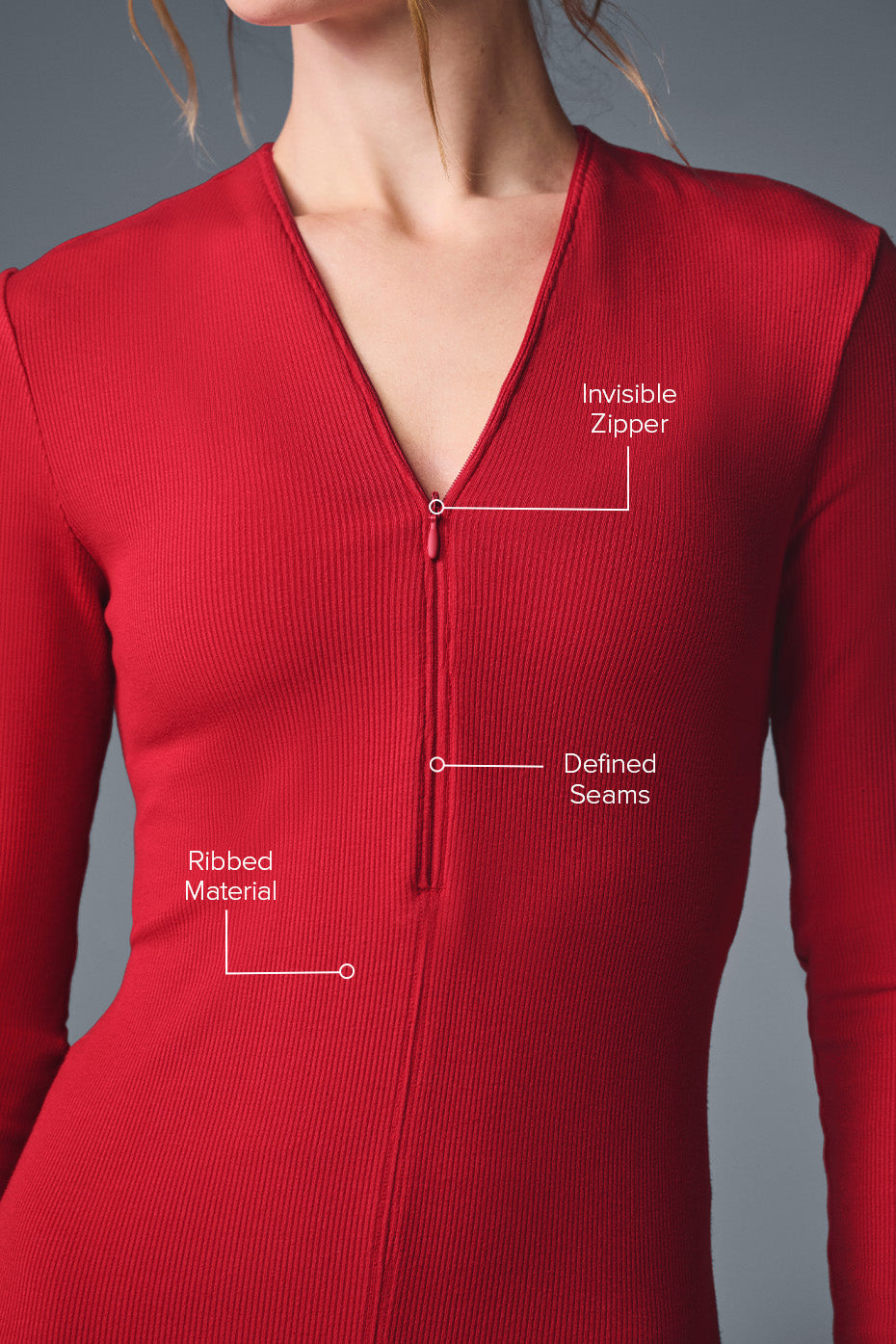 Close-up of a red ribbed long sleeve top featuring an invisible zipper and defined seams for a sleek silhouette.