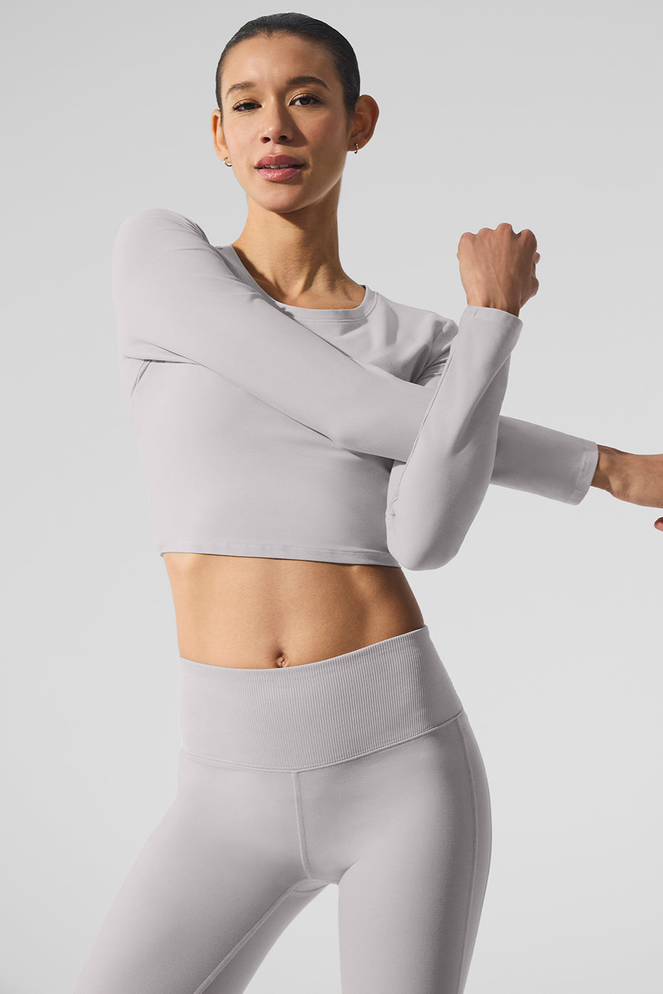 Model wearing Washed Alosoft Crop Finesse Long Sleeve in chic light gray with cropped silhouette.