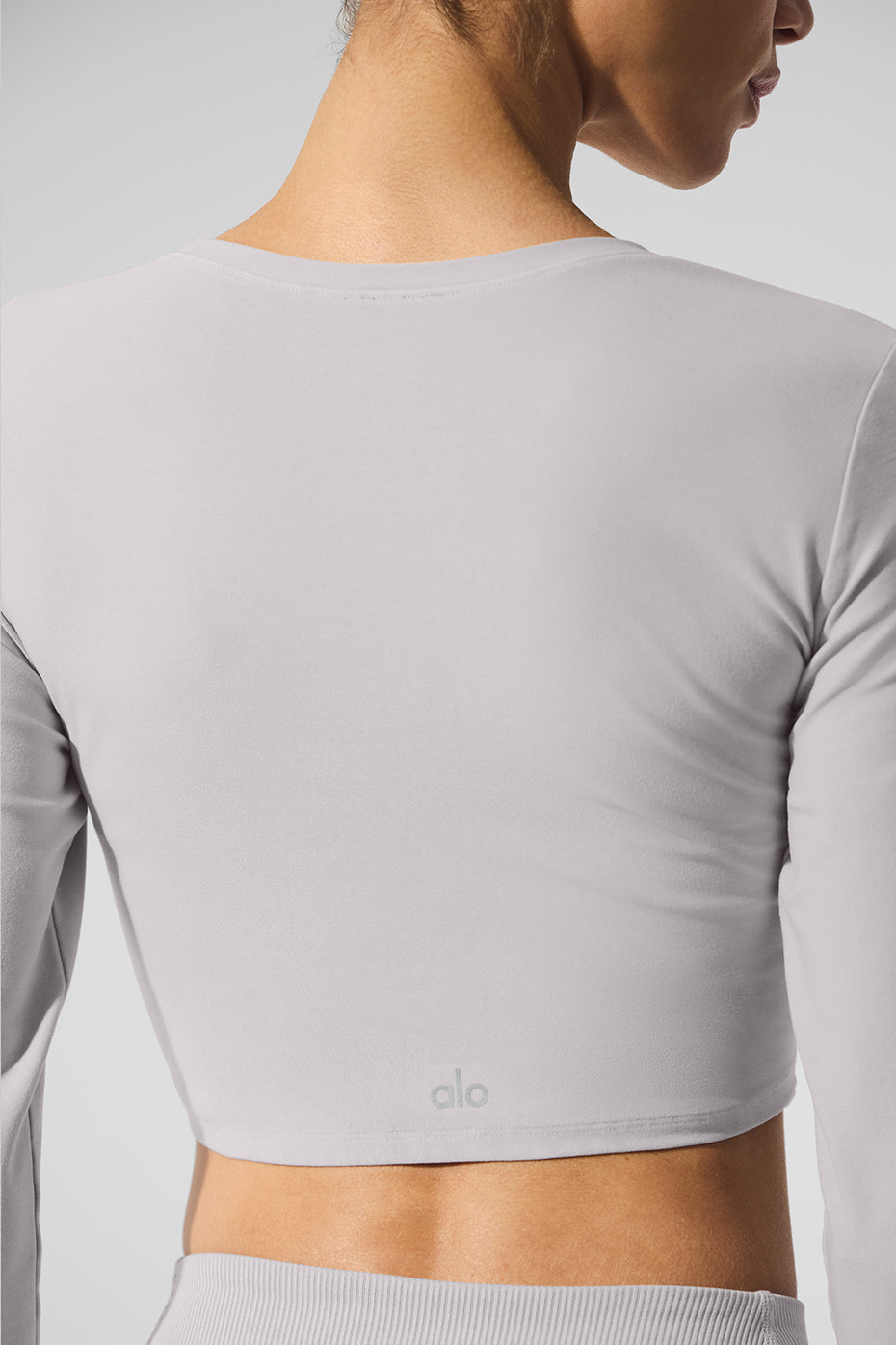 Back view of the Washed Alosoft Crop Finesse Long Sleeve featuring a sleek, cropped silhouette in a chic washed look.