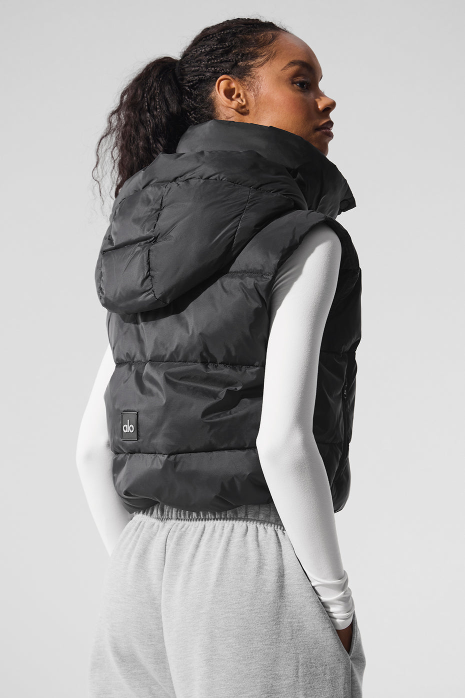 Gold Rush Puffer Vest in black, featuring a tall hooded collar and cinched waist for added warmth and style.