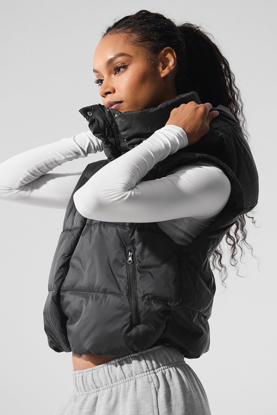 Model wearing a cozy-luxe Gold Rush Puffer Vest with a high collar, showcasing its cinched design and zip pockets.