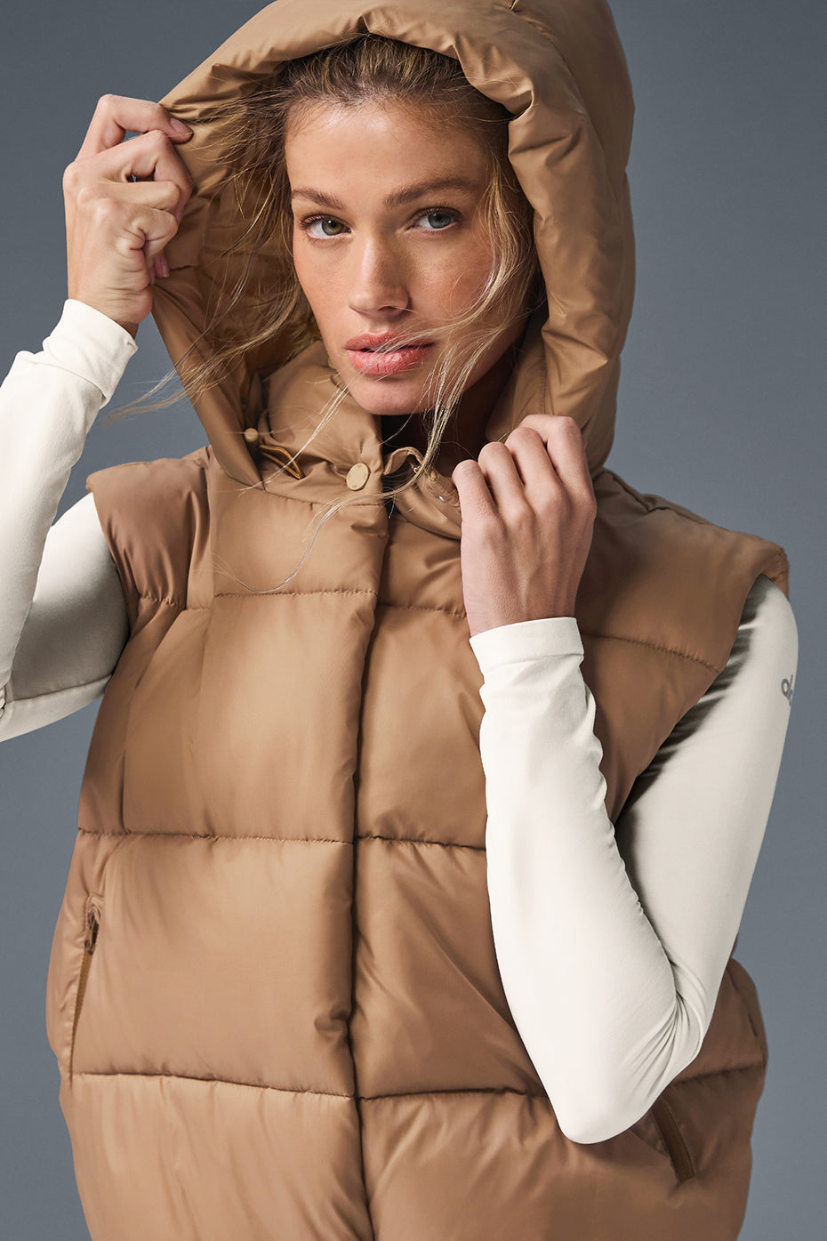 Model wearing Gold Rush Puffer Vest with a hood, showcasing its cozy-luxe design and flattering fit.