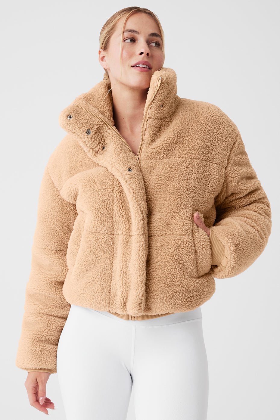 Sherpa Snow Angel Puffer in tan color featuring a tall collar and zippered pockets for warmth on cold days.