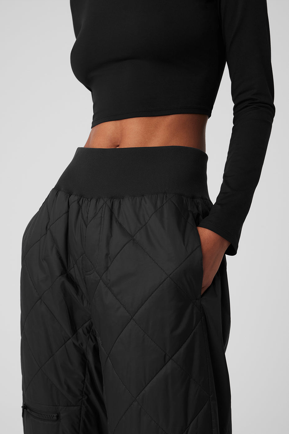 Close-up of high-waist snowrider puffer pant featuring quilted finish and wide ribbed waistband.