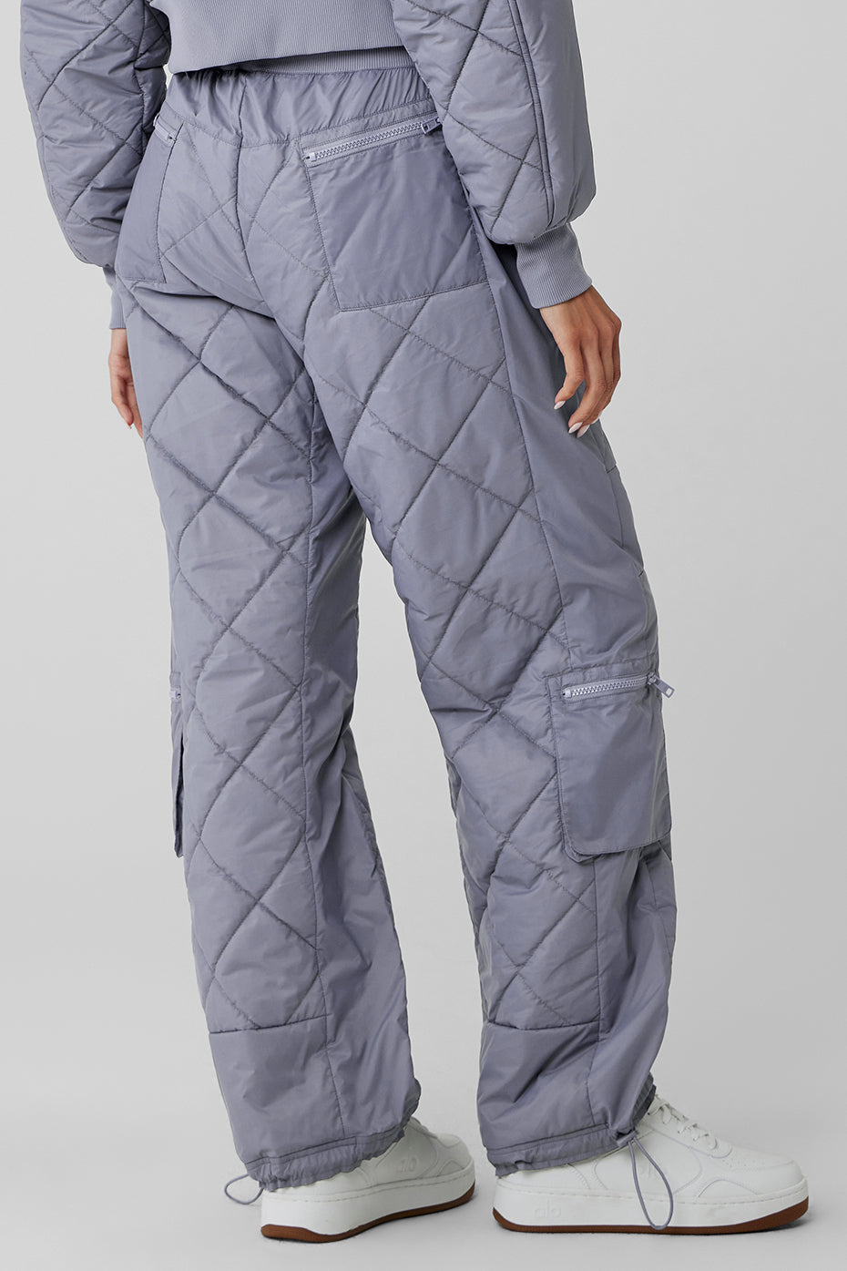High-waist Snowrider puffer pant with quilted finish and pockets shown from the back in light gray.