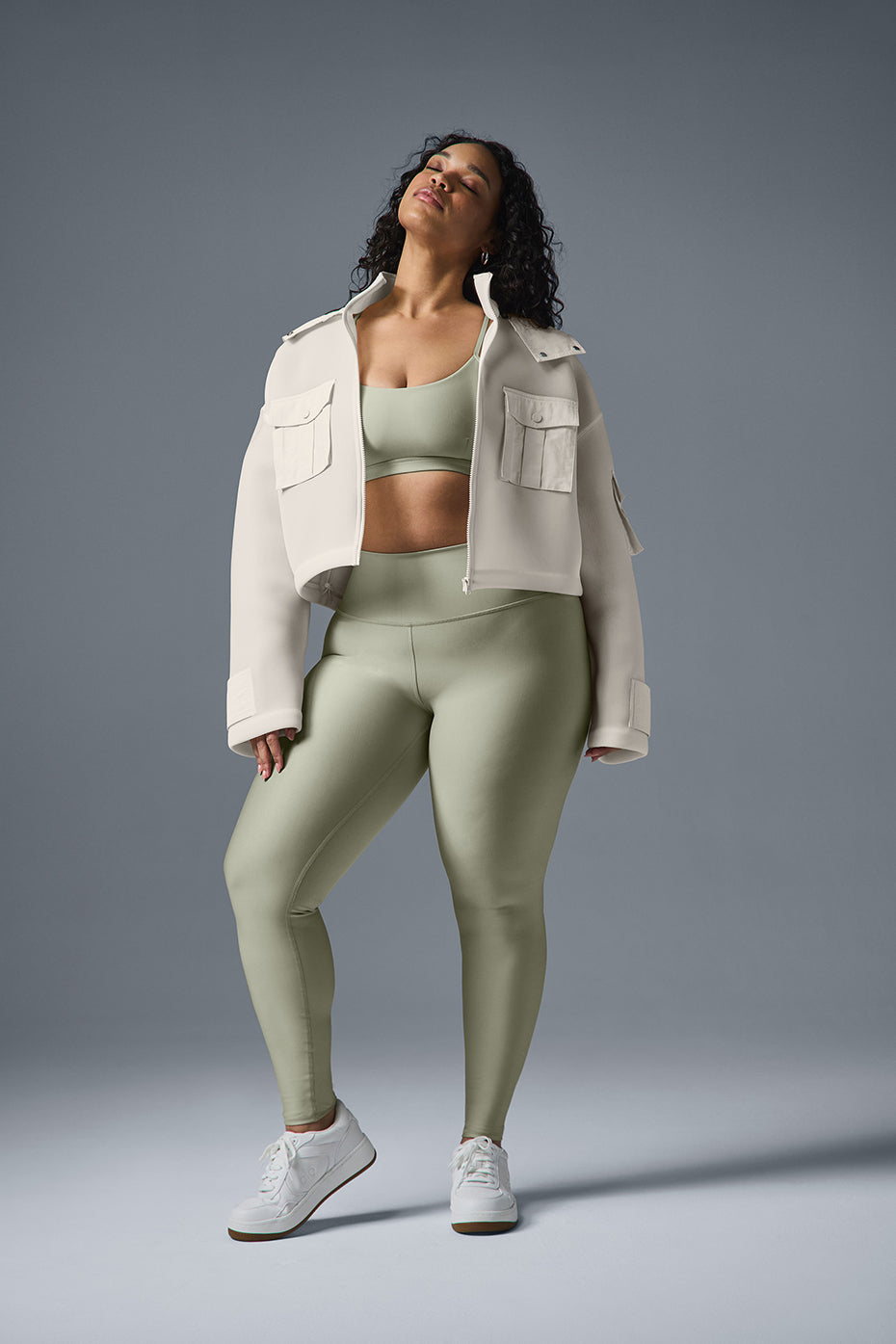 Model wearing a cropped cargo parka over a matching set, showcasing a stylish sporty look with baggy jeans and sneakers.