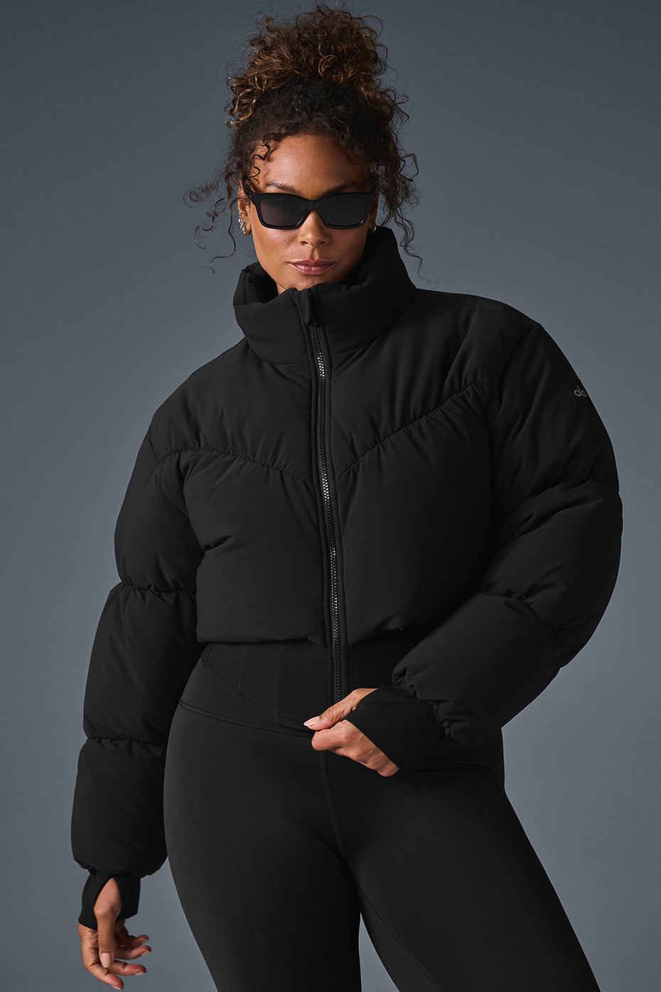 Main Act Corset Puffer jacket in black featuring a cropped silhouette and corset hemline, perfect for chilly days.