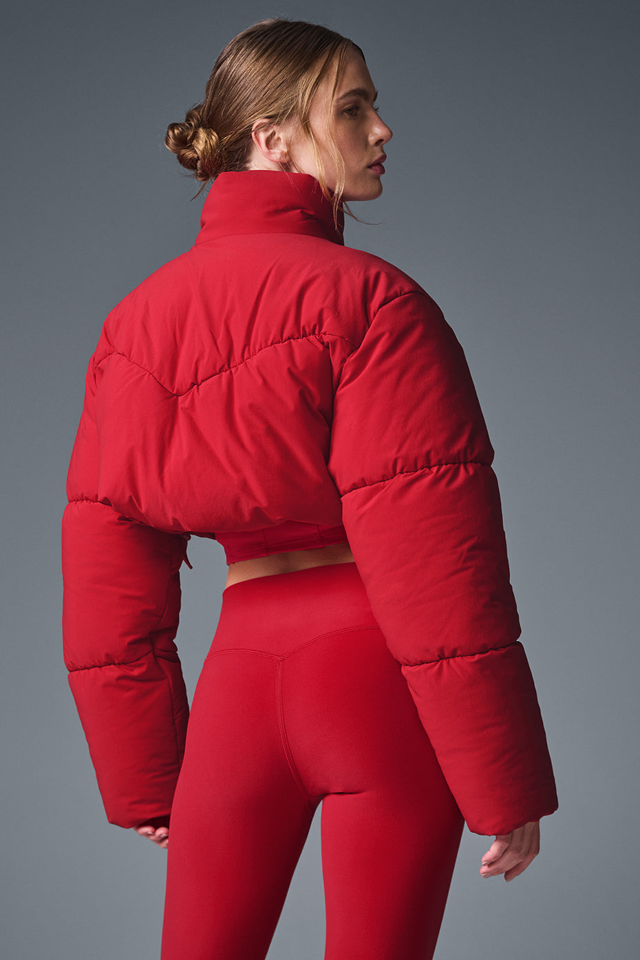 Main Act Corset Puffer in vibrant red with cropped silhouette and oversized sleeves for stylish warmth.