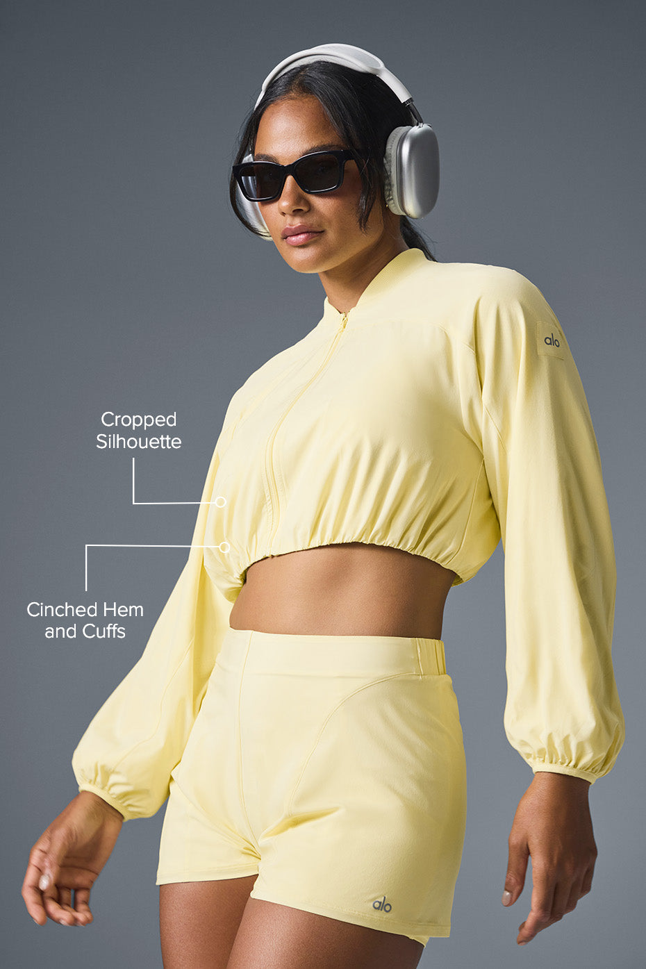 Model wearing Tiebreaker Jacket showcasing cropped silhouette and cinched cuffs, paired with matching shorts.
