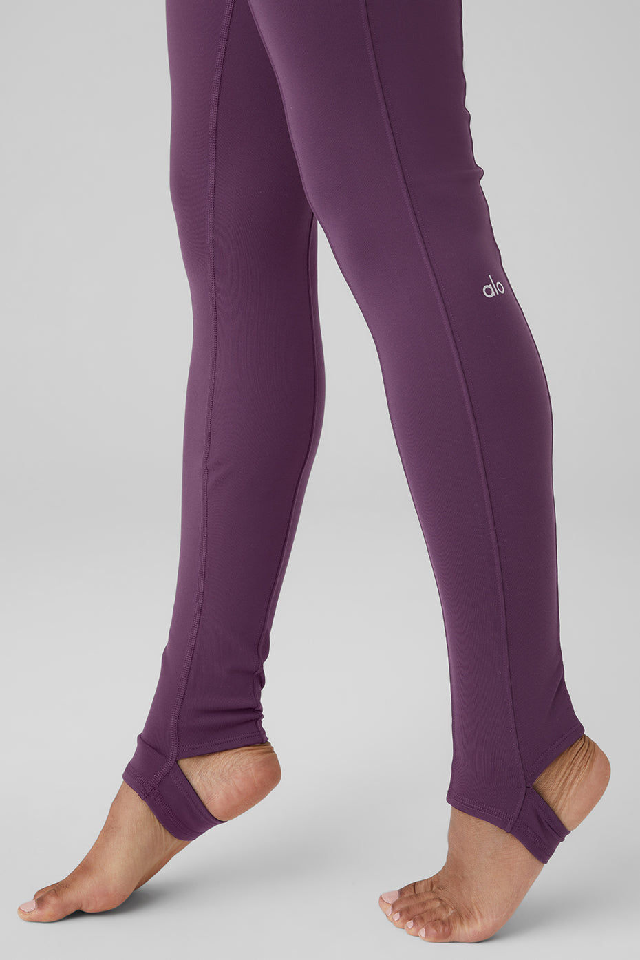 High-waist Enso legging in deep purple, featuring elevated seam detailing and toe hooks for Pilates and performance comfort.