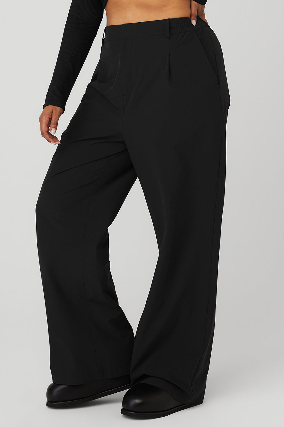 High-waist pursuit trouser in black with relaxed wide-leg fit and classic pleats for stylish comfort.