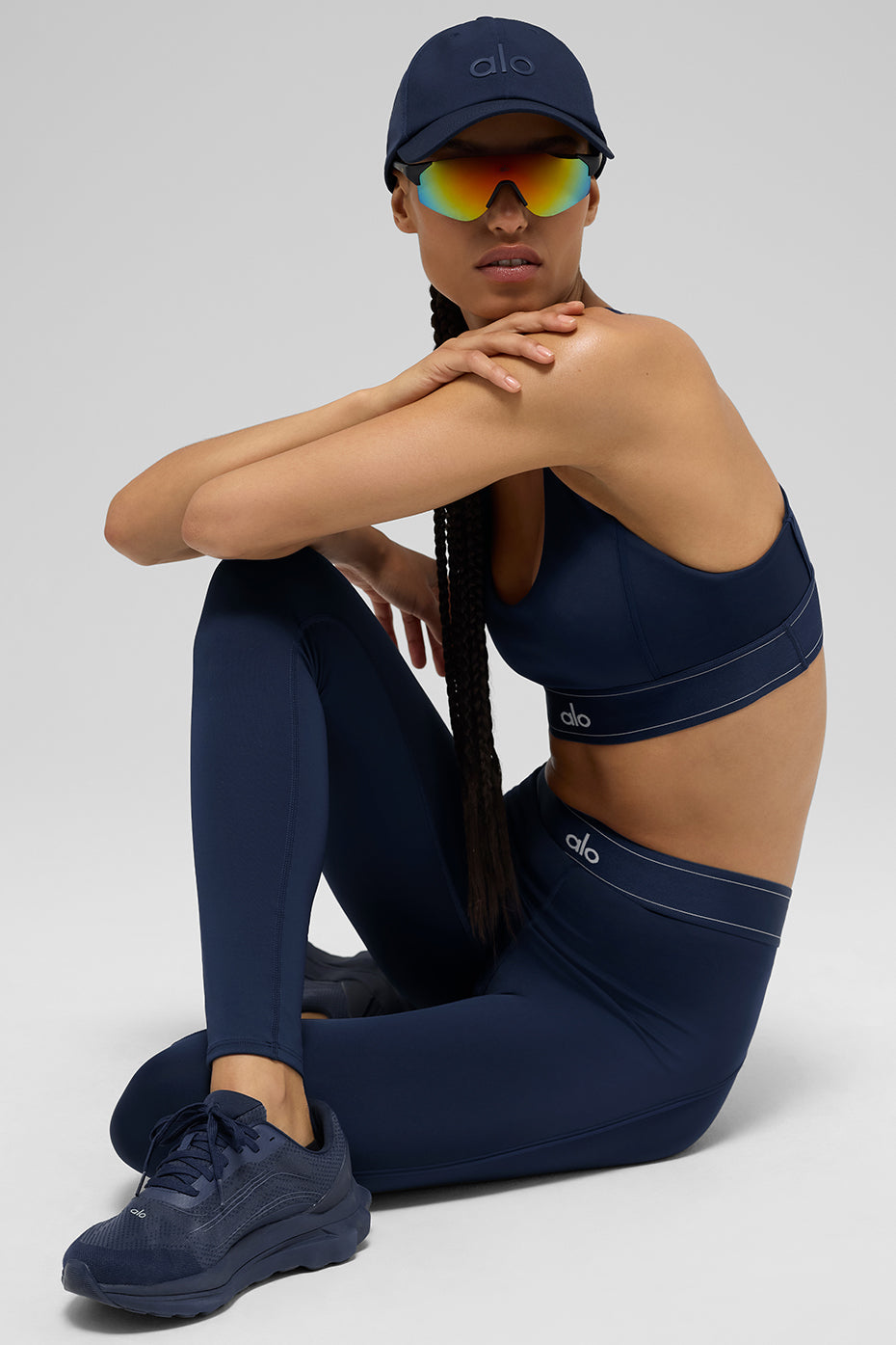 Model wearing Airlift high-waist legging and matching sports bra in navy with sporty accessories.