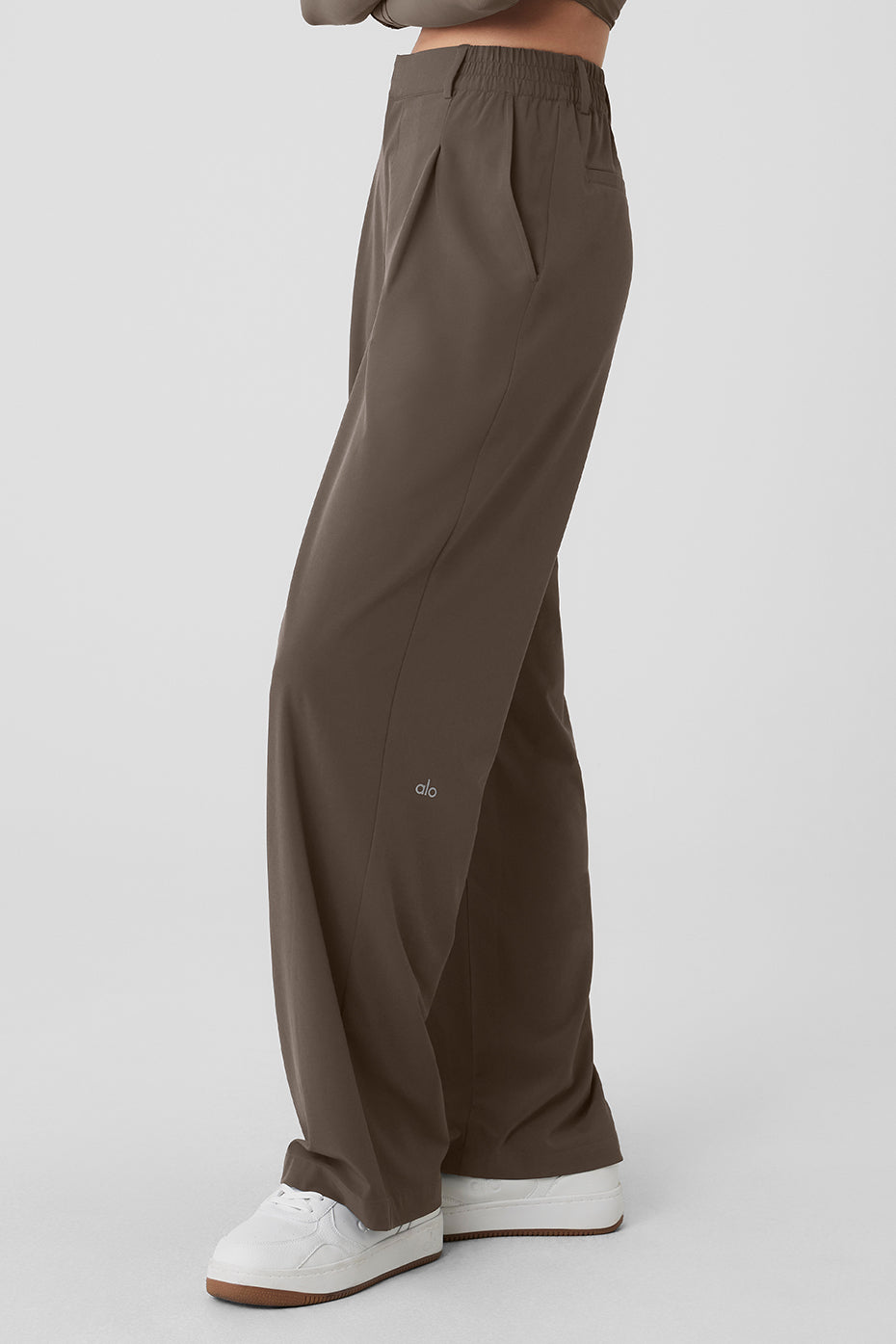 High-waist pursuit trouser featuring a relaxed wide-leg fit, elastic waistband, and classic pleats in a sleek brown design.