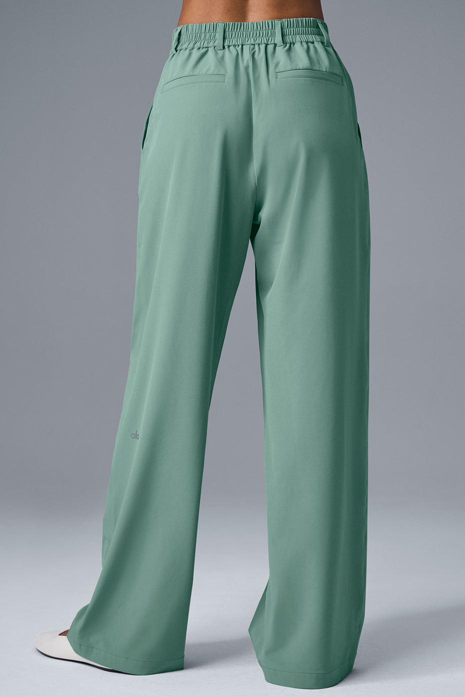 High-waist pursuit trouser in green with a relaxed wide-leg fit and high-rise waistband, showcasing tailored details.