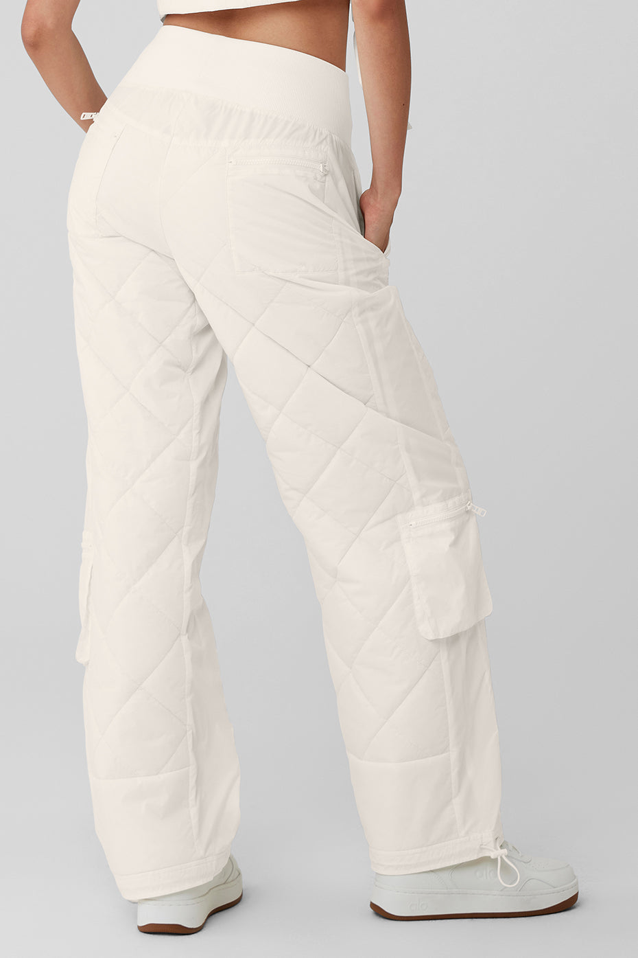 Back view of high-waist Snowrider puffer pant with quilted finish and ribbed waistband, showcasing pockets and bungee hems.