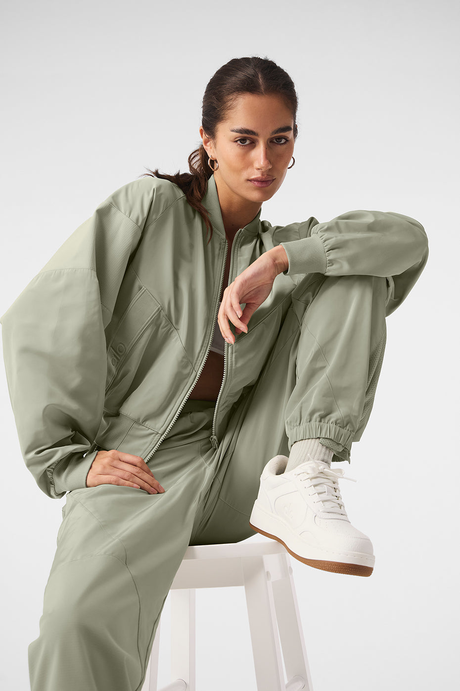 Sporty model wearing Mixed Media Reinvention Jogger and matching jacket in light green, showcasing relaxed fit and trendy style.